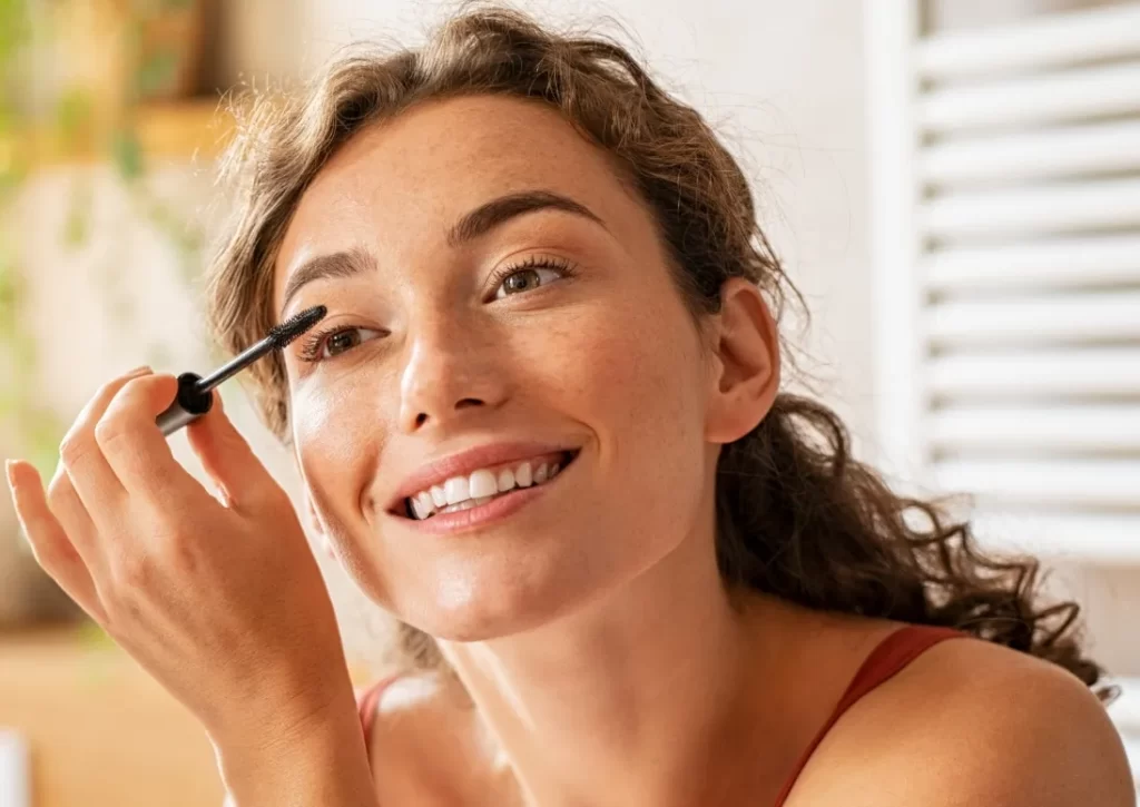 beautiful woman applying mascara utc